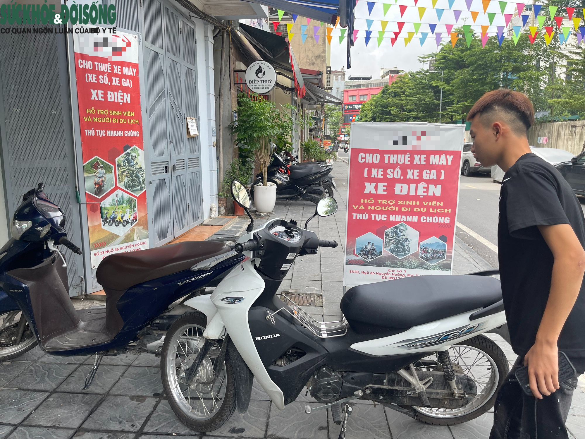 Nhân viên cửa hàng cho thuê xe máy làm các thủ tục để giao xe cho khách.